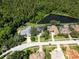 Overhead shot of a neighborhood showcasing properties with pools and water views, nestled alongside a lush green forest at 4848 Quill Ct, Palm Harbor, FL 34685