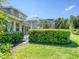 Well-manicured backyard landscaping frames the screened-in pool enclosure of this property at 4848 Quill Ct, Palm Harbor, FL 34685