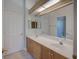 Bright bathroom featuring a dual sink vanity, tile floors, and large mirror at 4848 Quill Ct, Palm Harbor, FL 34685