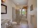 Modern bathroom featuring a glass-enclosed shower, tiled floors, and natural light through the window at 4848 Quill Ct, Palm Harbor, FL 34685