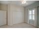 Cozy bedroom with a ceiling fan, closet, and window with white curtains at 4848 Quill Ct, Palm Harbor, FL 34685