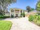 Stunning home with classic architecture, prominent columns, and a paver driveway, enveloped by mature landscaping at 4848 Quill Ct, Palm Harbor, FL 34685