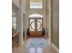 Welcoming foyer with high ceilings, a decorative front door, and hardwood floors, accented by a stylish area rug at 4848 Quill Ct, Palm Harbor, FL 34685