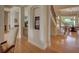 Hallway with wooden floors and staircase leading to an upstairs area, featuring decorative archways and art niches at 4848 Quill Ct, Palm Harbor, FL 34685