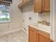 Bright laundry room with cabinets, sink, and window at 4848 Quill Ct, Palm Harbor, FL 34685