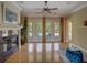 Bright living room featuring a fireplace, hardwood floors, and French doors leading to the outdoor pool area at 4848 Quill Ct, Palm Harbor, FL 34685