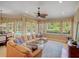 Inviting living room with ample seating, large windows offering backyard views, and a ceiling fan at 4848 Quill Ct, Palm Harbor, FL 34685