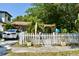 Charming home with a white picket fence, mature landscaping and a parked car visible from the street at 5045 2Nd S Ave, St Petersburg, FL 33707