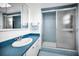 Retro bathroom with blue tiling featuring a shower with a sliding door and a sink with vanity at 5108 Brittany S Dr # 607, St Petersburg, FL 33715