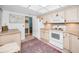 Bright kitchen featuring white appliances and neutral cabinets with an adjacent dining area at 5108 Brittany S Dr # 607, St Petersburg, FL 33715