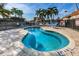 Small outdoor pool with clear water surrounded by a brick patio and an iron fence at 5108 Brittany S Dr # 607, St Petersburg, FL 33715