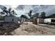 Open view of a demolition in progress, showing the structure and the surrounding grounds at 512 Carolyne St, Temple Terrace, FL 33617