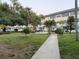 Condo complex with manicured lawn area and outdoor seating surrounded by palm trees at 5720 13Th N Ave # 106B, St Petersburg, FL 33710