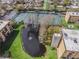 Aerial view of the condo community showing tennis courts, mature trees, and a tranquil pond with fountain at 5820 N Church Ave # 212, Tampa, FL 33614