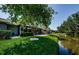 Landscaped backyard featuring a patio, pond, and verdant lawn at 70 Ashley Ln, Oldsmar, FL 34677