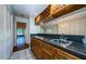 Bar area with granite counters, wood cabinets, wine rack, and view into the living space at 70 Ashley Ln, Oldsmar, FL 34677