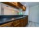 This dry bar features wood cabinets, black countertops, storage for wine bottles and glassware at 70 Ashley Ln, Oldsmar, FL 34677
