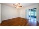 Bright bedroom with hardwood floors, ceiling fan, and sliding door to patio at 70 Ashley Ln, Oldsmar, FL 34677