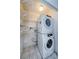 Efficient laundry area with stacked washer and dryer, maximizing space with shelving at 70 Ashley Ln, Oldsmar, FL 34677