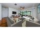 The spacious living room features wood floors, neutral furniture, and a sliding glass door to the outside porch at 70 Ashley Ln, Oldsmar, FL 34677