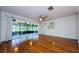 The spacious living room features wood floors, an overhead fan, and a sliding glass door to the outside porch at 70 Ashley Ln, Oldsmar, FL 34677