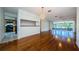 This living room features hard wood floors and sliding glass doors leading to a screened in porch and kitchen access at 70 Ashley Ln, Oldsmar, FL 34677