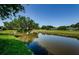 Picturesque pond view reflecting lush greenery and a clear blue sky on the golf course at 70 Ashley Ln, Oldsmar, FL 34677