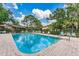 Community pool area with clear blue water, surrounded by lounge chairs and lush landscaping at 70 Ashley Ln, Oldsmar, FL 34677
