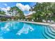 Relaxing community pool with sun loungers and trees reflecting in the clear blue water at 70 Ashley Ln, Oldsmar, FL 34677
