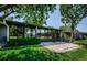 Exterior view of a sunroom and patio surrounded by lush landscaping at 70 Ashley Ln, Oldsmar, FL 34677