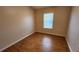 Cozy bedroom with wood laminate flooring and a bright window creating a comfortable living space at 7530 Red Mill Cir, New Port Richey, FL 34653