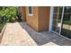 Paver patio leads to sliding glass door, offering seamless indoor-outdoor living at 7530 Red Mill Cir, New Port Richey, FL 34653