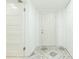 A hallway with white walls, patterned tile flooring, and white doors at 8008 N Alaska St, Tampa, FL 33604