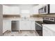 Well-lit kitchen with white cabinets, stainless appliances, and contrasting countertops at 8008 N Alaska St, Tampa, FL 33604