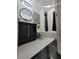 Modern bathroom featuring a sleek black vanity, round mirror, and stylish black and white accents at 824 Greenbelt Cir, Brandon, FL 33510