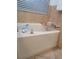 Bathtub featuring tile backsplash, silver faucet, a wooden tray, and a window at 824 Greenbelt Cir, Brandon, FL 33510