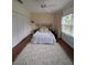 Bright bedroom features a decorative rug, natural lighting, and a queen-sized bed with stylish headboard at 824 Greenbelt Cir, Brandon, FL 33510