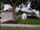 Charming home exterior featuring a blue front door, manicured lawn, and mature trees at 824 Greenbelt Cir, Brandon, FL 33510