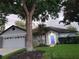Charming single-story home featuring a well-manicured lawn, attached garage and a vibrant blue front door at 824 Greenbelt Cir, Brandon, FL 33510
