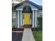 Close up of the front door featuring a bright yellow front door flanked by white columns at 824 Greenbelt Cir, Brandon, FL 33510