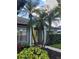 Charming home featuring a bright yellow front door flanked by white columns and lush tropical landscaping at 824 Greenbelt Cir, Brandon, FL 33510