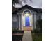 Inviting front entrance features a bright blue door, white columns, and lush landscaping at 824 Greenbelt Cir, Brandon, FL 33510