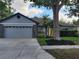 Charming single Gathering home featuring a light gray exterior, well maintained lawn and landscaping, and a two-car garage at 824 Greenbelt Cir, Brandon, FL 33510
