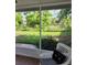 View from the screened porch to the grassy backyard, green foliage, and providing an outdoor living space at 824 Greenbelt Cir, Brandon, FL 33510