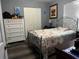 Relaxing bedroom featuring a metal bed frame, wood floors, and a closet for storage at 8516 N Dixon Ave, Tampa, FL 33604