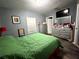 Comfortable bedroom showcasing dark wood floors, grey walls, a bed, and a large dresser at 8516 N Dixon Ave, Tampa, FL 33604