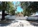Charming home featuring a white fence and mature trees enhancing its curb appeal on a sunny day at 8516 N Dixon Ave, Tampa, FL 33604