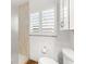 Bathroom featuring a toilet, cabinet and window with shutters at 8801 Gulf Blvd, St Petersburg, FL 33706