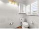 Bathroom with a toilet, window and overhead lighting at 8801 Gulf Blvd, St Petersburg, FL 33706