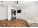 Bright bedroom featuring wood floors, closet, ceiling fan, one window with white shutters, and a TV at 8801 Gulf Blvd, St Petersburg, FL 33706